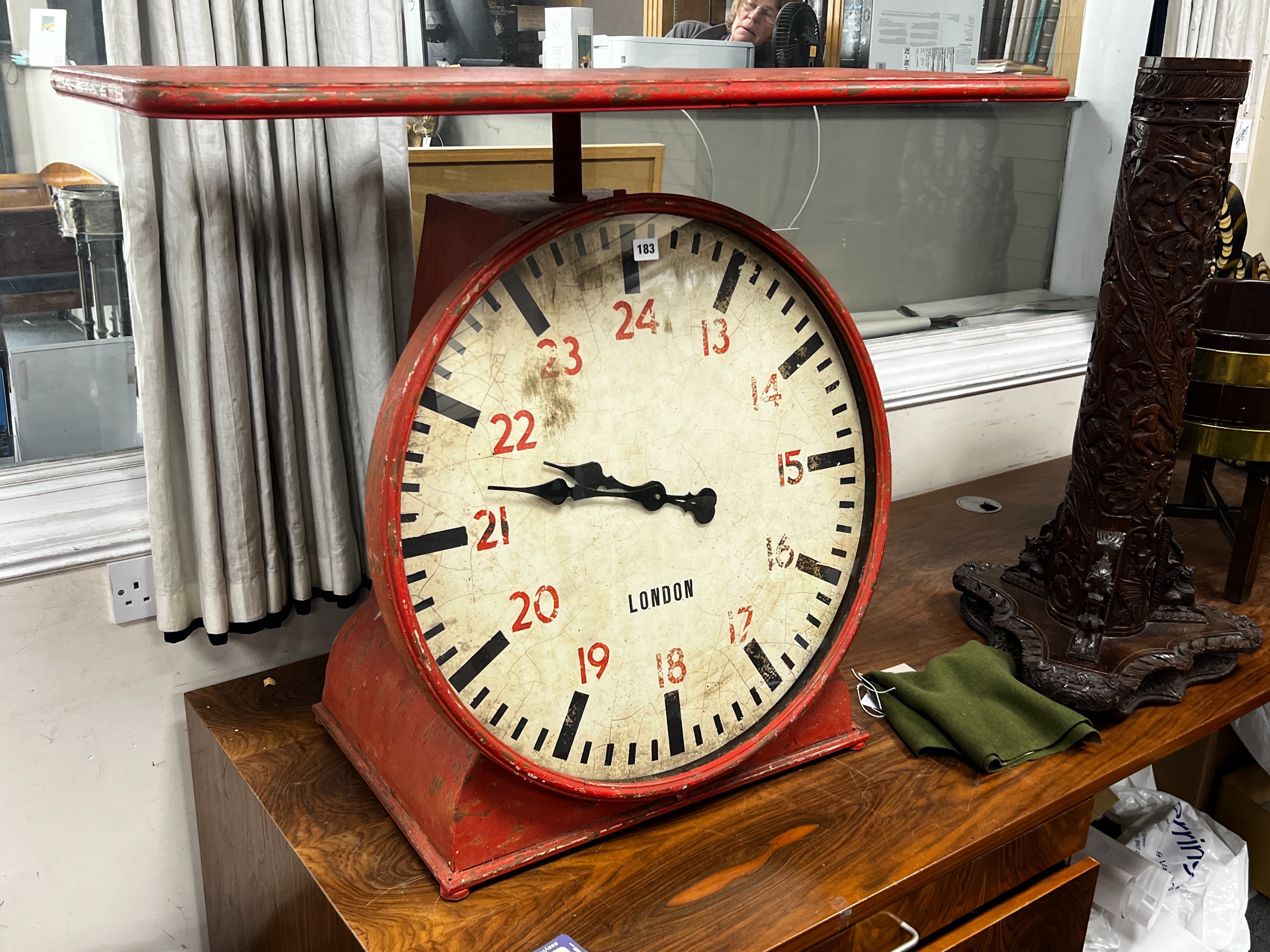 An industrial style painted metal clock console table modelled as a set of scales, width 102cm, depth 46cm, height 80cm.